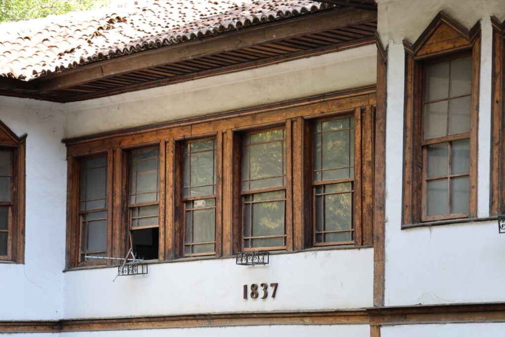 Detaje të fasadës së Sarajeve të Toptanëve, ku ruhen dritaret prej druri dhe mbishkrimi historik "1837". Foto: Media Amfora